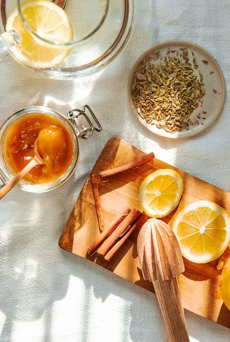 Citrons, cannelle et grains de fenouil sur une planche en bois